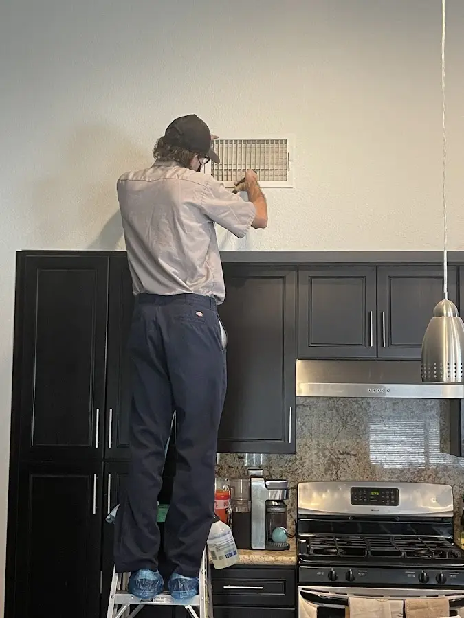 Technician inspecting an air vent during HVAC service in Catasauqua